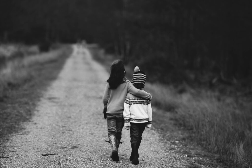 Photo of two children walking down a path