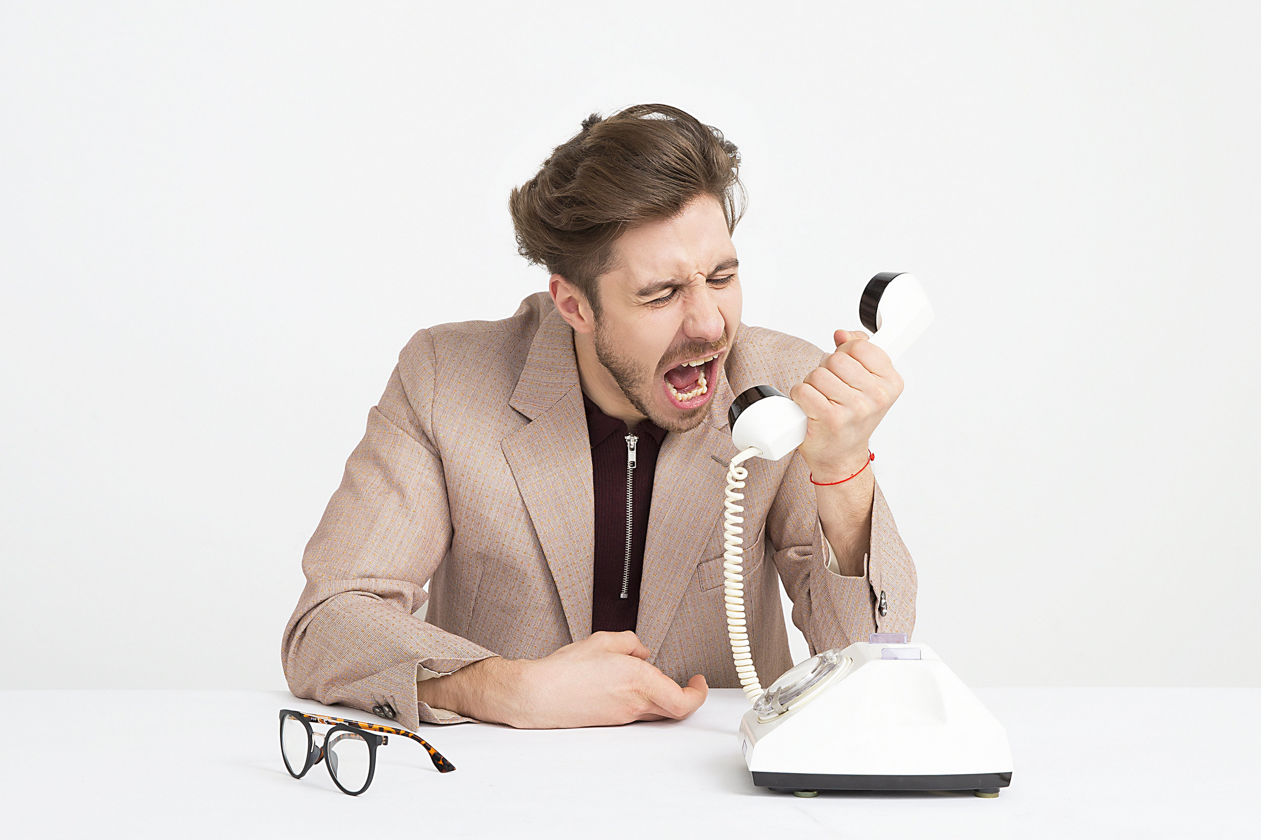 Man shouting into a phone handset