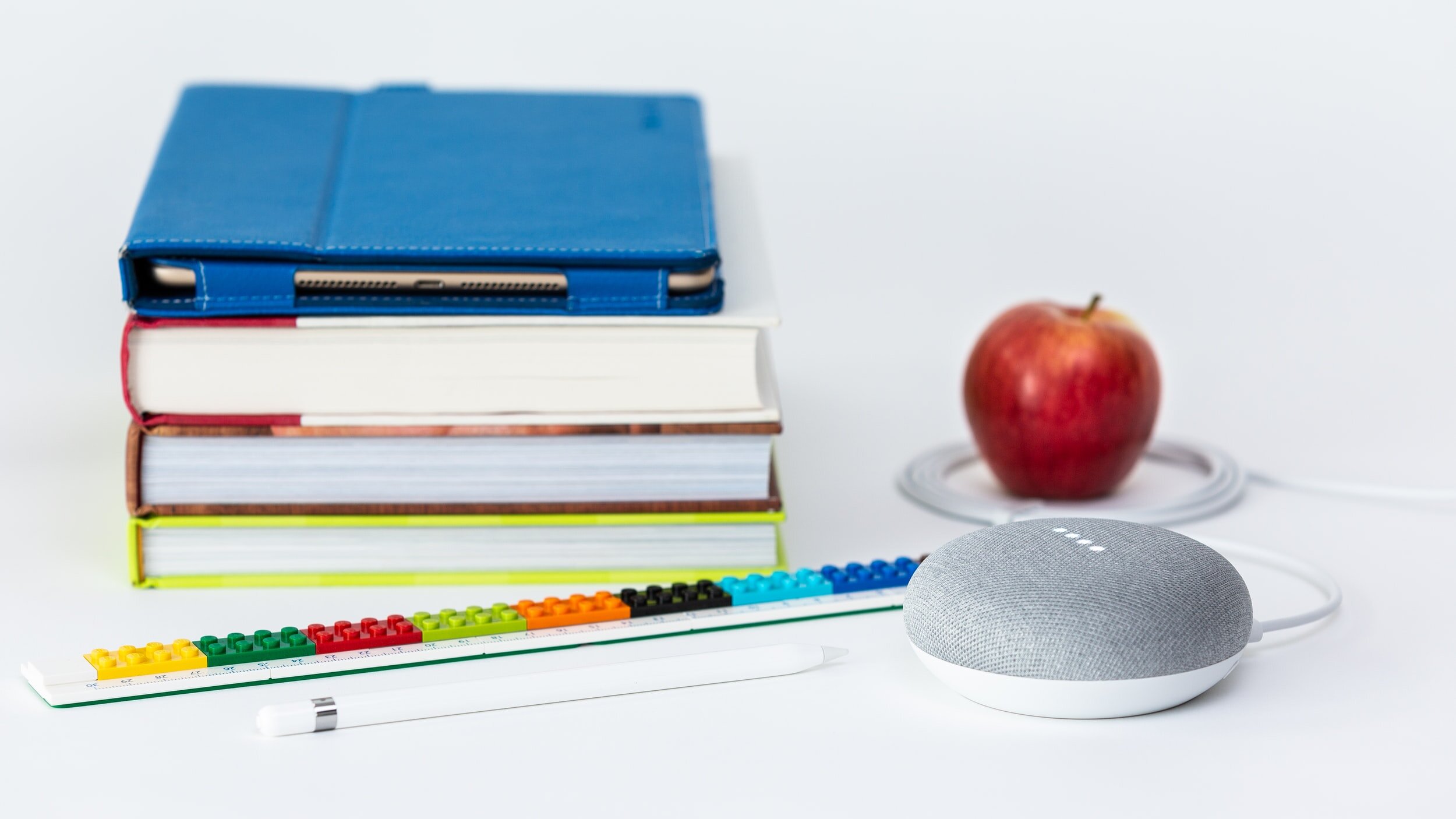 Stack of books with an apple beside them