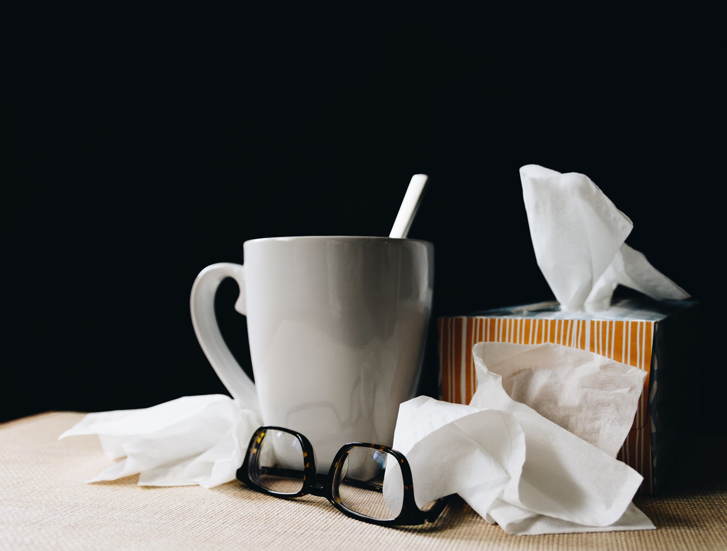 Table with a cup and a box of Kleenex