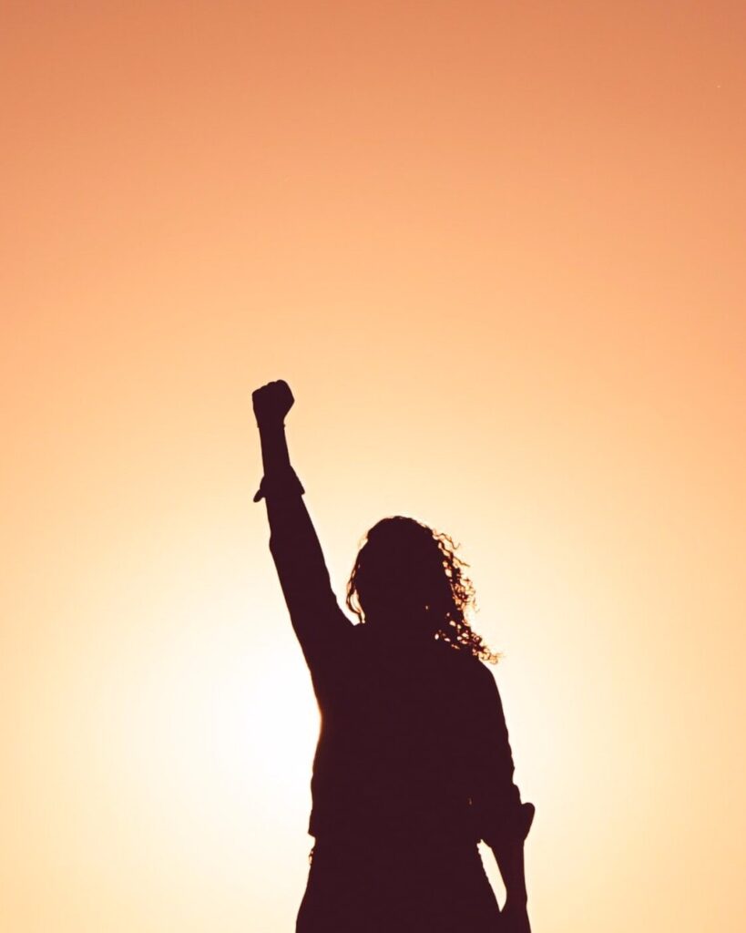 Silhouette of woman raising her fist in the air