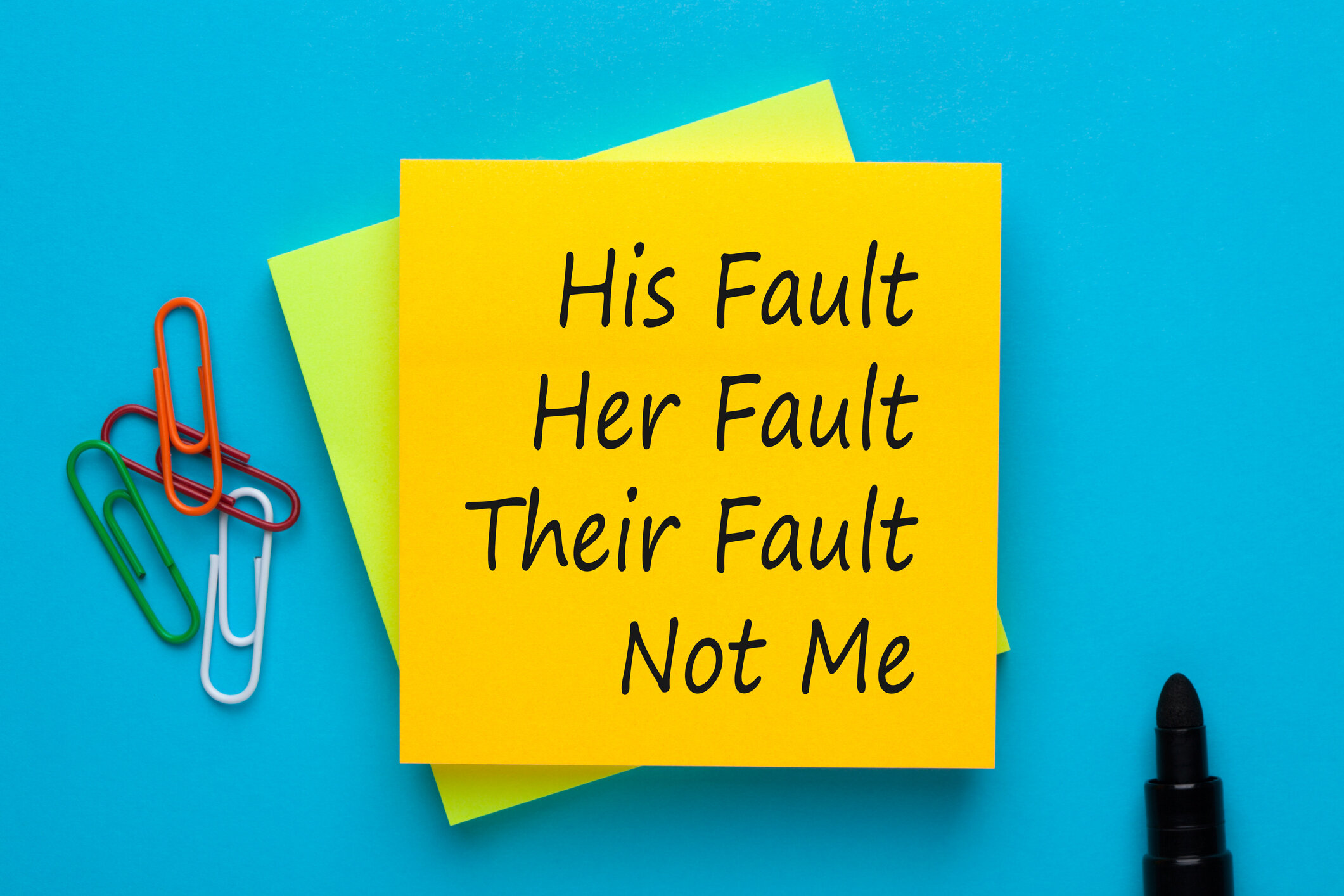 A post-it note that says his fault, her fault, their fault, not me