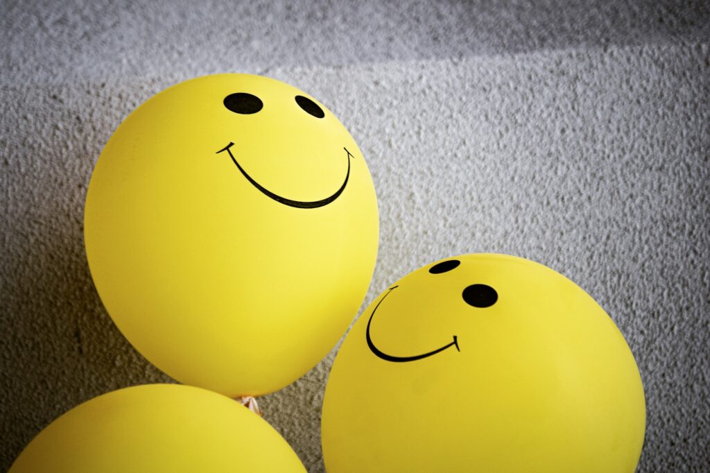 Yellow balloons with happy faces drawn on them