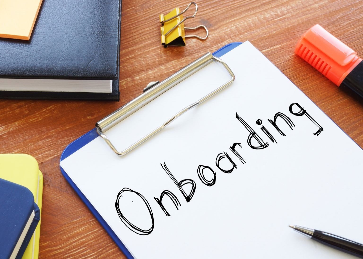 The word onboarding written on a paper on a clip board