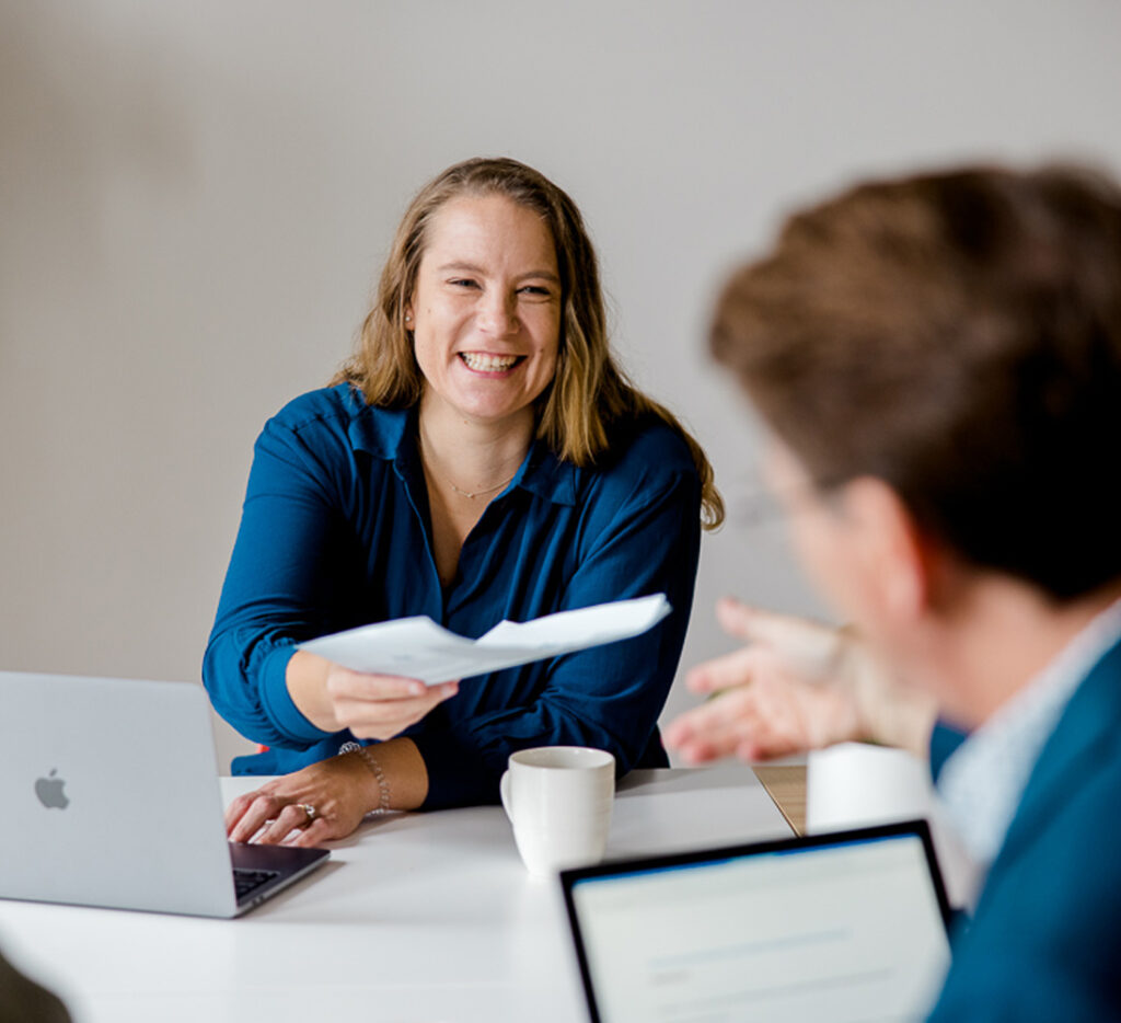 Brandy handing a document to a client