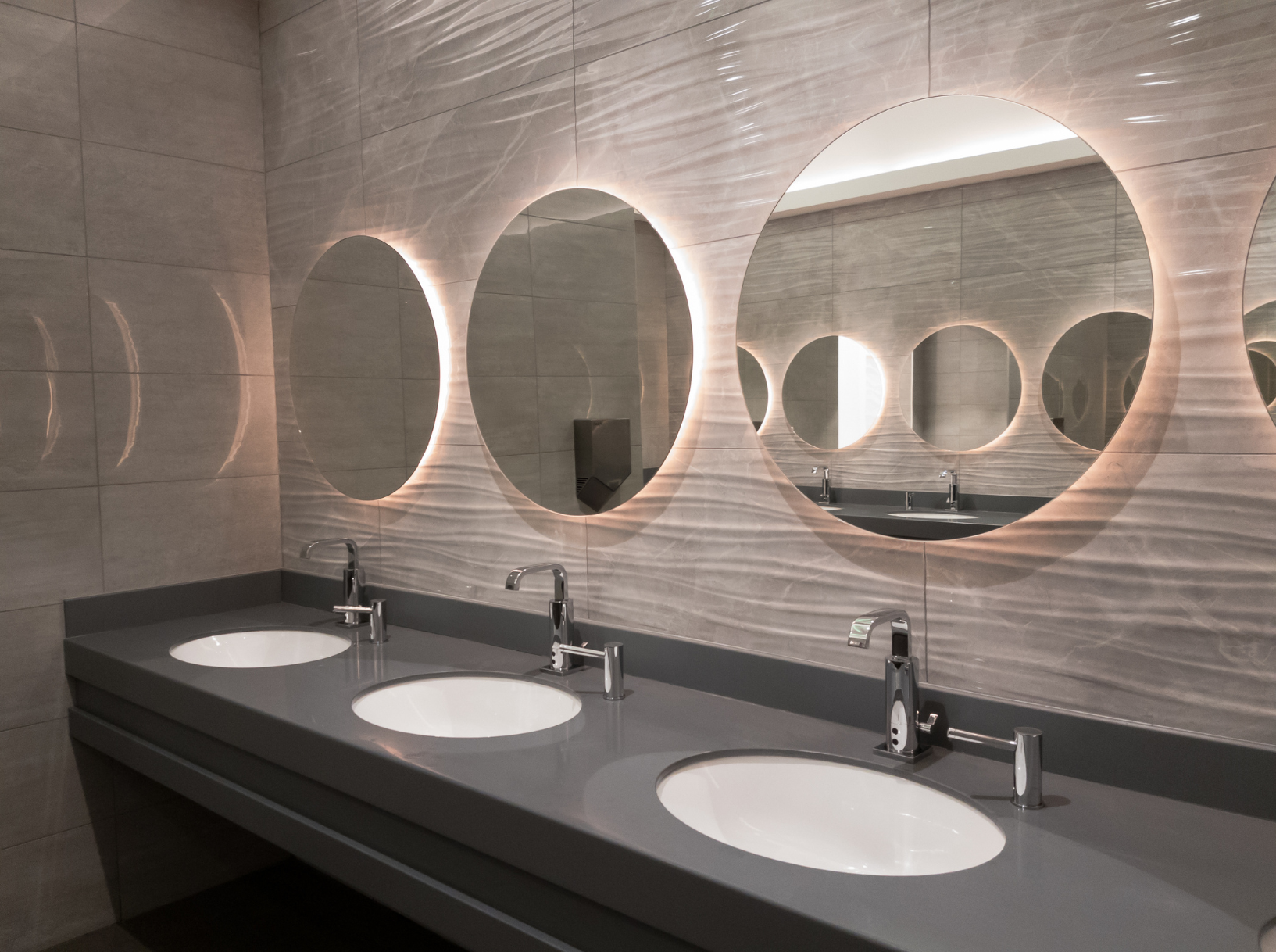 Modern workplace washroom with clean sinks and mirrors showing proper hygiene standards.